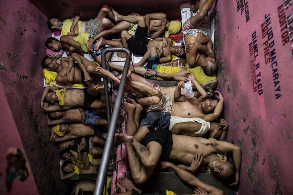 Foto da série Vida Dentro da Prisão Mais Superlotada das Filipinas, de Noel Celis, que mostra dezenas de prisioneiros dormindo nos degraus da escada da prisão Quezon City em Manila - Sputnik Brasil