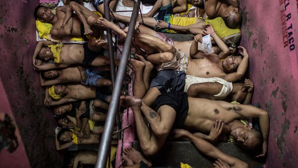 Foto da série Vida Dentro da Prisão Mais Superlotada das Filipinas, de Noel Celis, que mostra dezenas de prisioneiros dormindo nos degraus da escada da prisão Quezon City em Manila - Sputnik Brasil