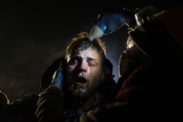 Imagem tirada por Amber Bracken retrata um homem sendo tratado com leite de magnésio pela polícia após ter sido atacado com gás de pimenta durante uma greve no estado de Dakota do Norte - Sputnik Brasil