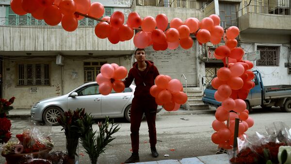 Homem sírio segura balões em frente de uma loja de venda de presentes para o Dia dos Namorados na cidade de Al-Qamishli, nordeste da Síria, 13 de fevereiro de 2017 - Sputnik Brasil