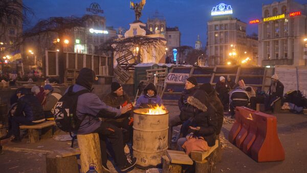 Apoiantes da adesão da Ucrânia à UE se aquecem perto de uma fogueira na Praça da Independência, Kiev, Ucrânia - Sputnik Brasil
