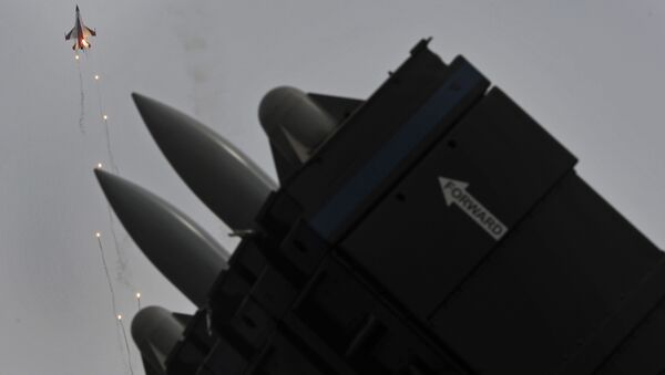 Mísseis Spyder superfície-ar em uma exposição estática são observados enquanto um jato F-16 da esquadrilha acrobática da Força Aérea de Singapura, Cavaleiros Negros, lança foguetes luminosos no quarto dia do Singapore Air Show em Singapura, na sexta-feira, 14 de fevereiro de 2014 - Sputnik Brasil