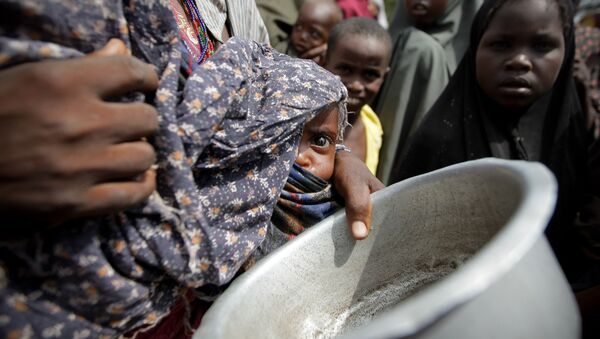 Uma mulher segurando um bebê espera por comida em um campo para desabrigados perto de Mogadíscio, Somália (Arquivo) - Sputnik Brasil