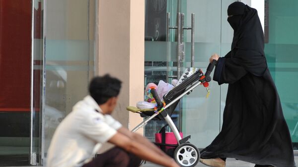 Uma mulher saudita passa por um trabalhador estrangeiro em 7 de novembro de 2013 em Riad. - Sputnik Brasil