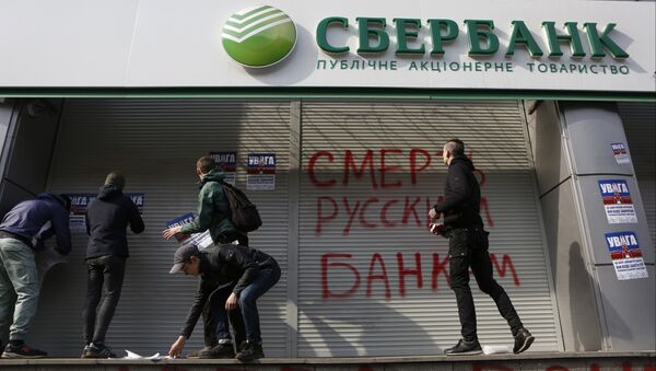Radicals in front of a Sberbank branch in Kiev, putting up posters which read Attention! This is a bank of an aggressor country. It will be closed. Urgently withdraw your money!, during a protest. Graffiti reads Death to Russian banks. March 10, 2017 - Sputnik Brasil