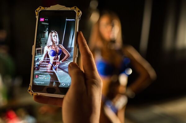 Uma participante posa para câmera do celular durante a Copa de fisiculturismo, fitness e desfile em biquíni na região de Omsk, Rússia - Sputnik Brasil
