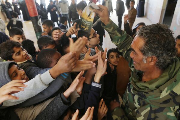 Membro do exército nacional da Líbia com os alunos da escola em Benghazi - Sputnik Brasil