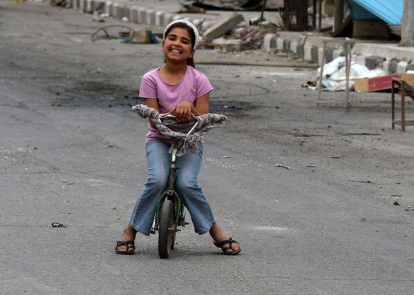 Criança em bicicleta numa das ruas de Palmira - Sputnik Brasil