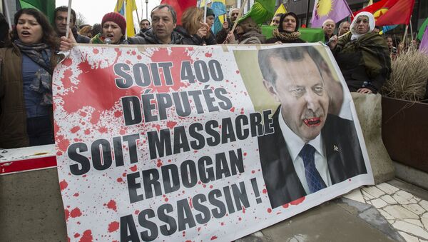 Manifestantes curdos exibem uma foto do presidente turco, Tayyip Erdogan, durante um protesto em frente a uma cúpula UE-Turquia, 7 de março de 2016 - Sputnik Brasil