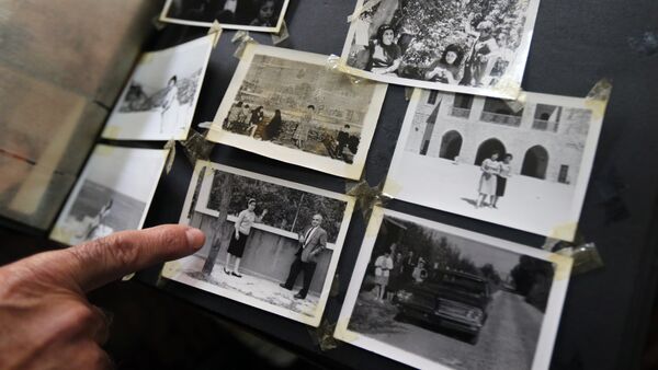 Khatchik Bakalian, um libanês armênio de 73 anos cujos pais fugiram do genocídio de armênios sob o Império Otomano em 1915, aponta para uma foto de seus pais no álbum de família - Sputnik Brasil