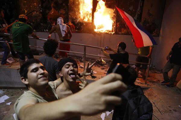 Homens tiram selfie com prédio do Congresso no fundo, durante confrontos com a polícia no Paraguai - Sputnik Brasil