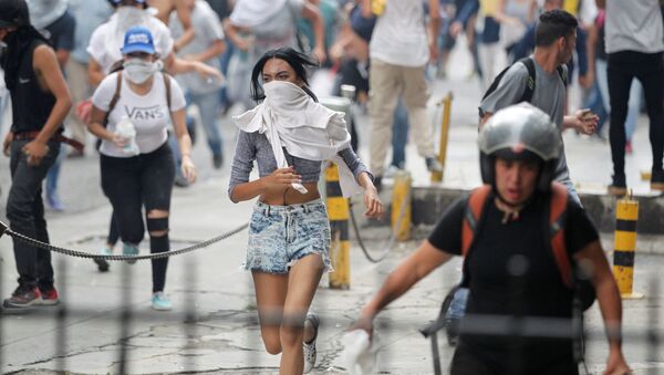 Manifestantes fogem da polícia durante os protestos contra o presidente venezuelano Nicolás Maduro em Caracas - Sputnik Brasil