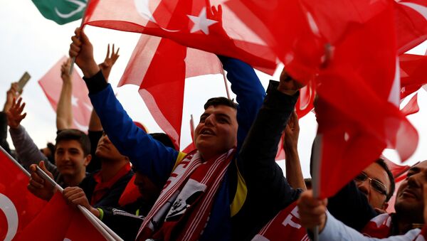 Os apoiantes do presidente turco, Recep Tayyip Erdogan, agitam bandeiras nacionais enquanto aguardam sua chegada ao Palácio Presidencial em Ancara, Turquia, após a realização do referendo que lhe concedeu novos poderes e mudou o regime de parlamentarista para presidencialista. - Sputnik Brasil