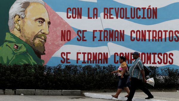 People walks pass a graffiti of Cuba's late president Fidel Castro in Santiago de Cuba - Sputnik Brasil