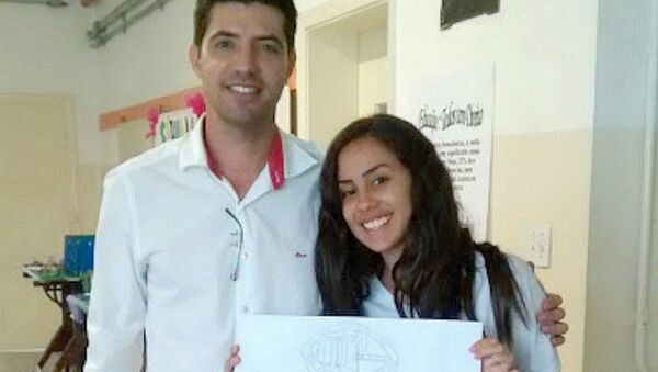 Professor David Cristiano de Almeida Postelhone e a estudante Isabela com o desenho que recebeu a menção honrosa da Nasa - Sputnik Brasil