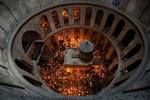 Fiéis com velas durante o milagre do Fogo Sagrado na Igreja do Santo Sepulcro em Jerusalém - Sputnik Brasil