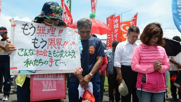 People offer a silent prayer in front of the US Kadena Air Base in Cyatan, Okinawa prefecture, to protest against the US military presence in Okinawa on May 21, 2016 - Sputnik Brasil