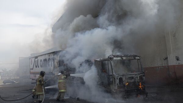 Bombeiros trabalham contra as chamas em caminhão incendiado por bandidos - Sputnik Brasil