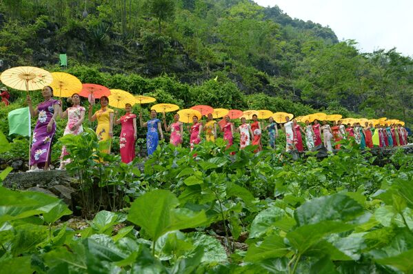 Mulheres exibem trajes tradicionais da China em meio a uma plantação em Laibin, em Guangxi - Sputnik Brasil
