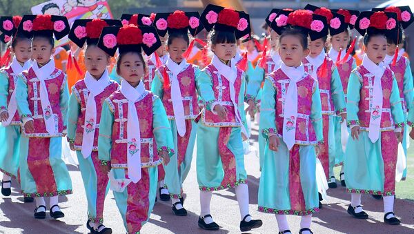 Pequenos estudantes desfilam com roupas tradicionais chinesas durante evento esportivo em Shenyang - Sputnik Brasil