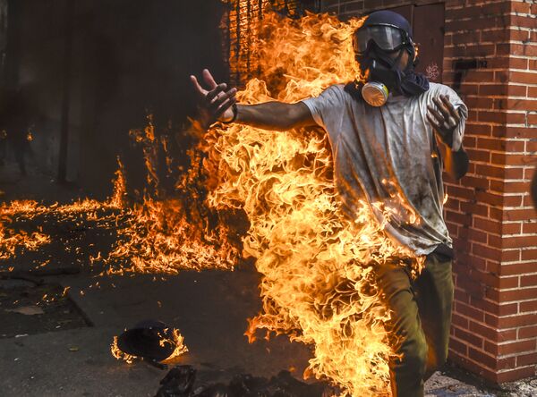 Manifestante em fogo durante protestos na capital venezuelana - Sputnik Brasil