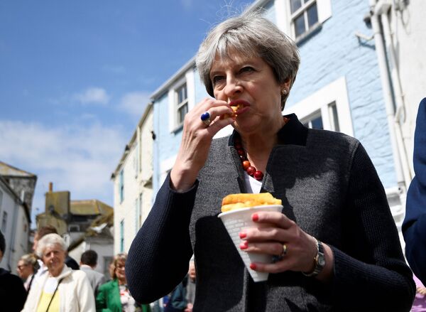 Premiê britânica, Theresa May, come batata chips durante encontro com eleitores no sudeste do Reino Unido - Sputnik Brasil