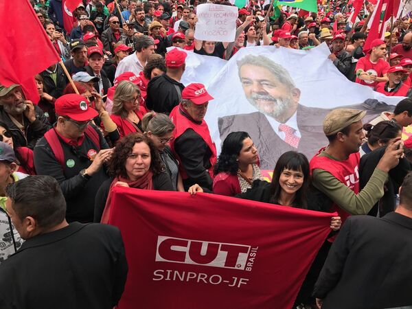 Membros da Central Única dos Trabalhadores perto de uma grande foto do ex-presidente Lula na praça Santos Andrade, em Curitiba - Sputnik Brasil