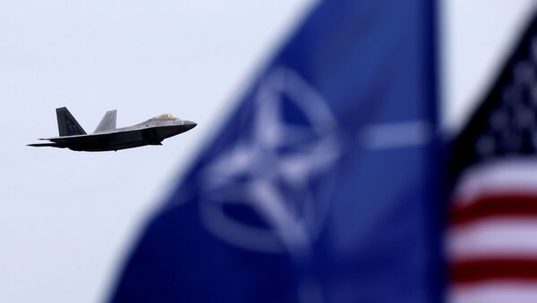 NATO and US flags flutter as U.S. Air Force F-22 Raptor fighter flies over the military air base in Siauliai, Lithuania, April 27, 2016. - Sputnik Brasil
