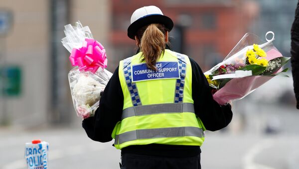A community support officer carries flowers near Manchester Arena in Manchester, Britain May 24, 2017. - Sputnik Brasil
