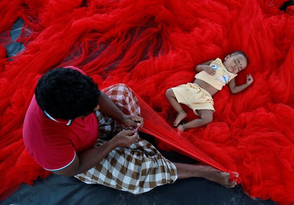 Pescador hindu com criança dormindo na rede - Sputnik Brasil