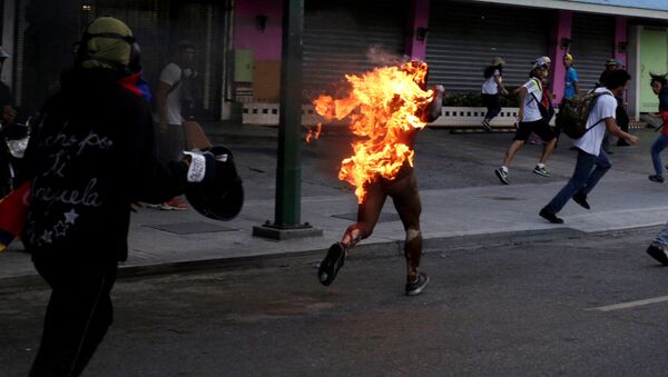 Manifestantes atearam fogo a um homem durante um protesto contra Nicolás Maduro na Venezuela - Sputnik Brasil