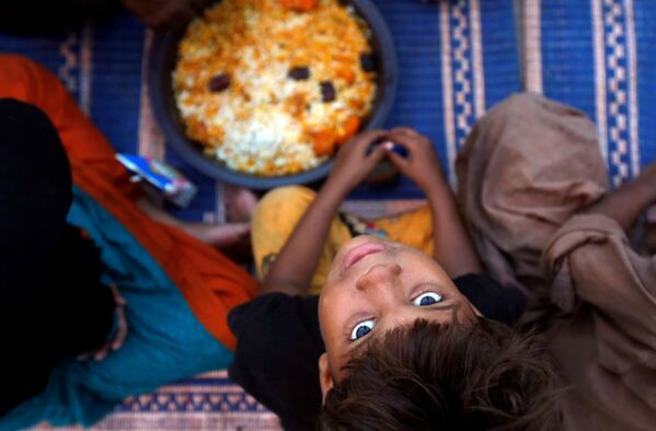 Um menino aguarda por sua porção de comida em um ponto de distribuição do decorrer do mês sagrado do Ramadã, no Paquistão - Sputnik Brasil