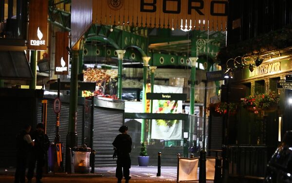 Oficial armado faz guarda em frente ao Borough Market, onde pelo menos duas pessoas foram esfaqueadas nesta madrugada em Londres. - Sputnik Brasil