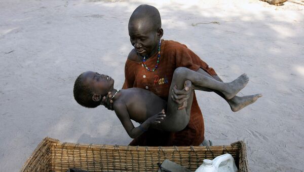 Uma mulher coloca o seu filho, que tem malária, em uma canasta para levá-lo a um hospital dos Médicos sem Fronteiras, no Sudão do Sul em 21 de dezembro de 2005 - Sputnik Brasil