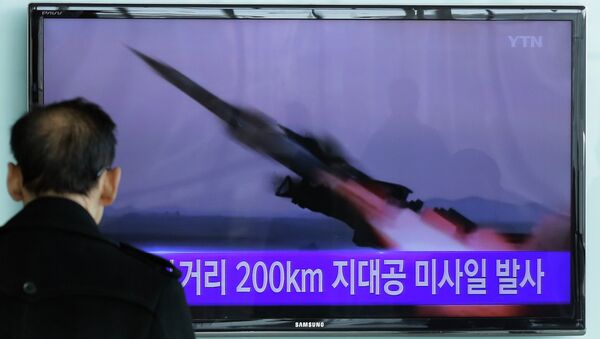 Um homem vê pela TV o disparo de um míssil em um treinamento militar da Coreia do Norte. - Sputnik Brasil