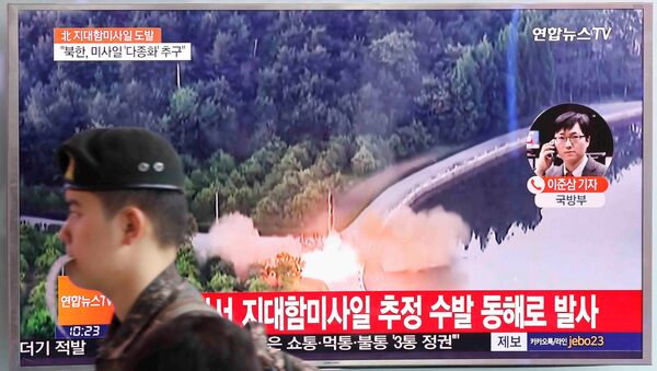 Soldado sul-coreano passa por uma TV que transmite uma reportagem a respeito do mais recente teste com mísseis da Coreia do Norte - Sputnik Brasil