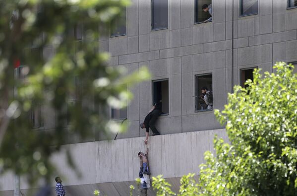 Homem entrega criança a um agente de segurança pela janela, enquanto o prédio do parlamento iraniano está sendo atacado pelos terroristas - Sputnik Brasil