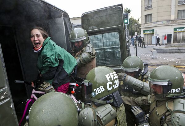 Participante de um protesto sendo detida em Santiago, capital chilena - Sputnik Brasil