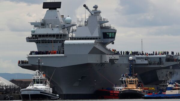 The British aircraft carrier HMS Queen Elizabeth is pulled from its berth by tugs before its maiden voyage, in Rosyth, Scotland, Britain June 26, 2017. - Sputnik Brasil