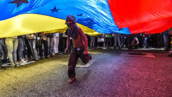Menino corre sob a bandeira venezuelana durante protestos de jornalistas e funcionários da mídia em Caracas - Sputnik Brasil