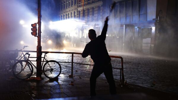 Manifestante joga uma garrafa contra a polícia de choque durante manifestações na cúpula do G20 em Hamburgo - Sputnik Brasil