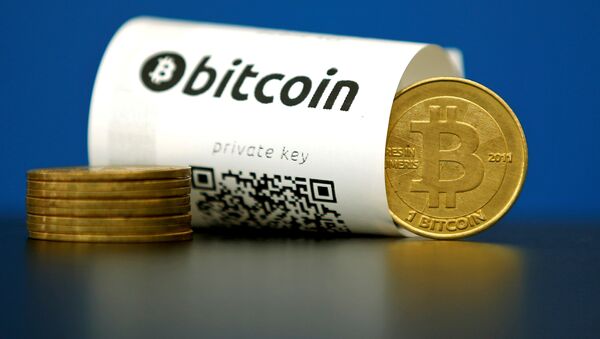 A Bitcoin (virtual currency) paper wallet with QR codes and a coin are seen in an illustration picture taken at La Maison du Bitcoin in Paris, France May 27, 2015 - Sputnik Brasil