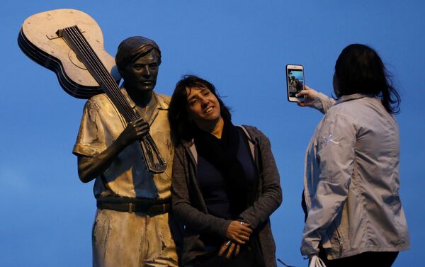 Mulher tira foto ao lado da estátua do músico Tom Jobim - Sputnik Brasil
