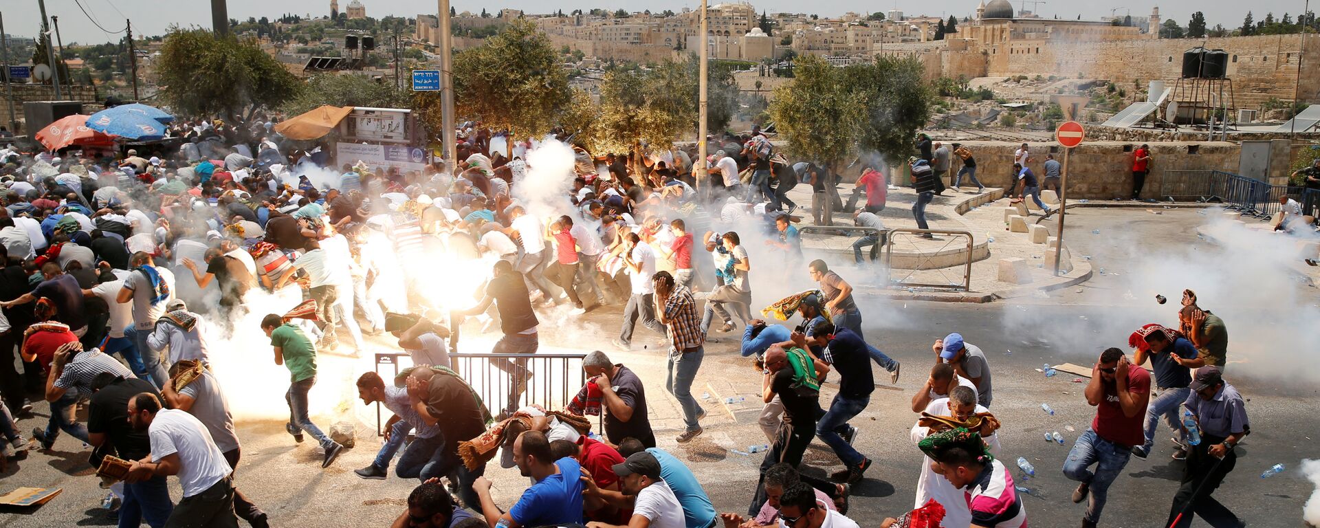 Palestinos fogem após polícia de Israel usar gás lacrimogêneo para dispersar multidão de fiéis durante manifestação, 21 de julho de 2017. - Sputnik Brasil, 1920, 14.04.2022