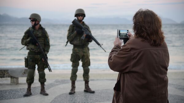 Pedestrem tiram fotos de militares que ocupam praia de Copacana em operação das Forças Armadas no Rio - Sputnik Brasil