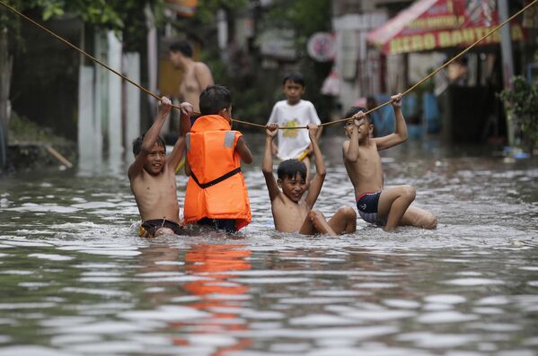 Meninos brincam na rua após a tempestade Nesar em Manila, capital filipina - Sputnik Brasil