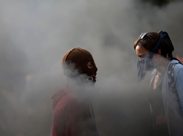 Manifestantes se olham enquanto se reúnem contra o governo do presidente da Venezuela, Nicolas Maduro, em Caracas - Sputnik Brasil