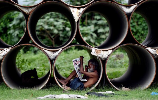 Indiano lê o jornal dentro de um tubo, na cidade de Nova Deli - Sputnik Brasil