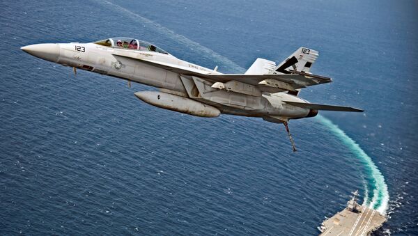Um caça-bombardeiro americano F/A-18F Super Hornet sobrevoa o porta-aviões da Marinha dos EUA USS Gerald R. Ford, enquanto este testa seus novos sistemas EMALS e AAG no Atlântico - Sputnik Brasil