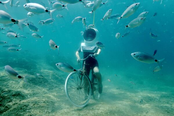 Uma mulher mergulha e finge estar dirigindo uma bicicleta no parque subaquático em Pula, na Croácia - Sputnik Brasil